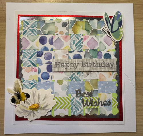 Handmade birthday card with floral design and text on a wooden surface